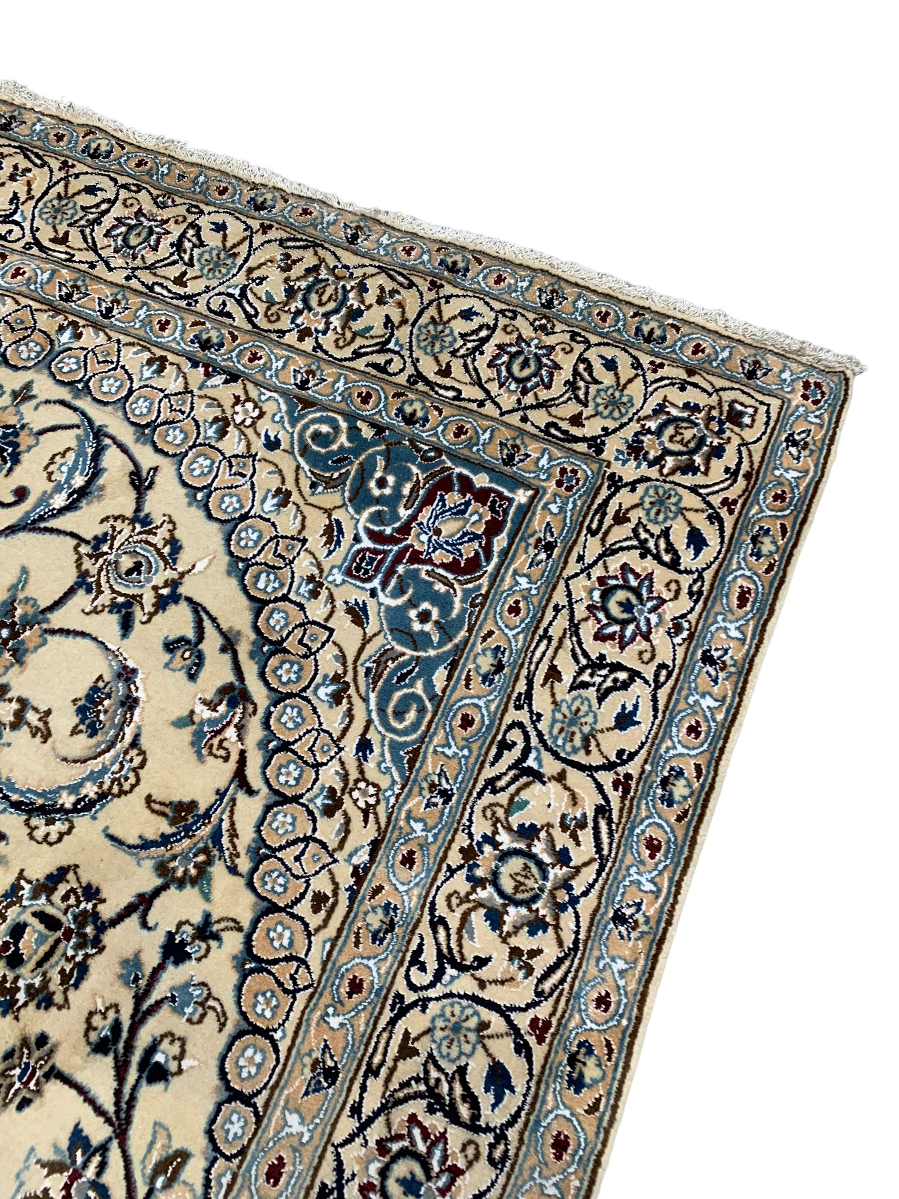 Persian Kashan ivory ground rug, central medallion surrounded by scrolling leafy branches and stylised flowerhead motifs, scrolling border decorated with further stylised plant motifs