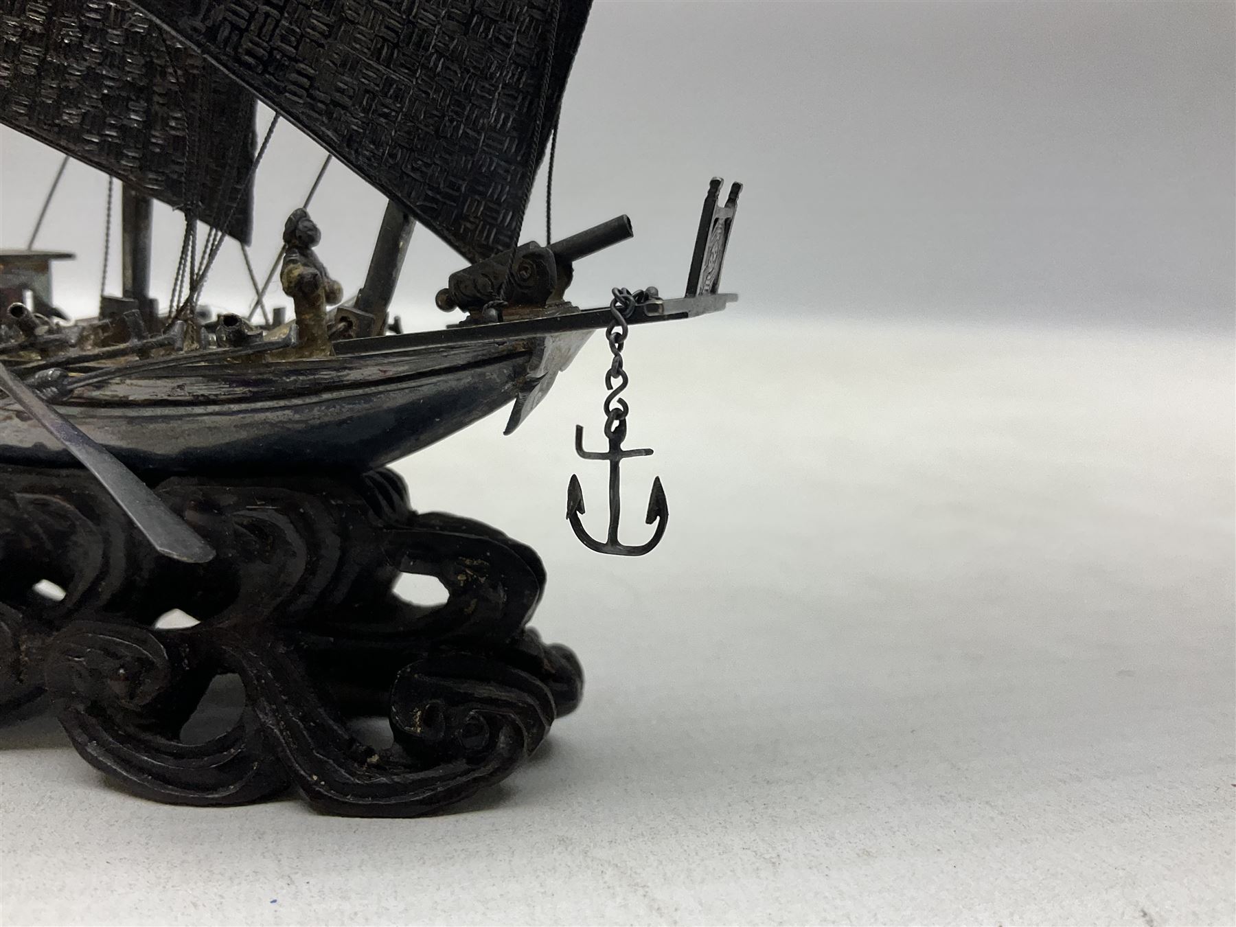 Chinese miniature silver model of a junk ship, with textured sails, mounted upon a carved wooden stand, H14cm