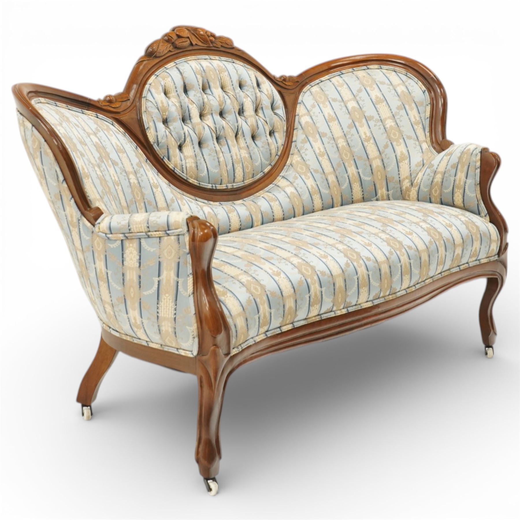 Victorian mahogany double cameo back sofa, the shaped back with central button upholstered oval panel and carved foliate crest above upholstered arms and seat, raised on cabriole legs terminating in castors