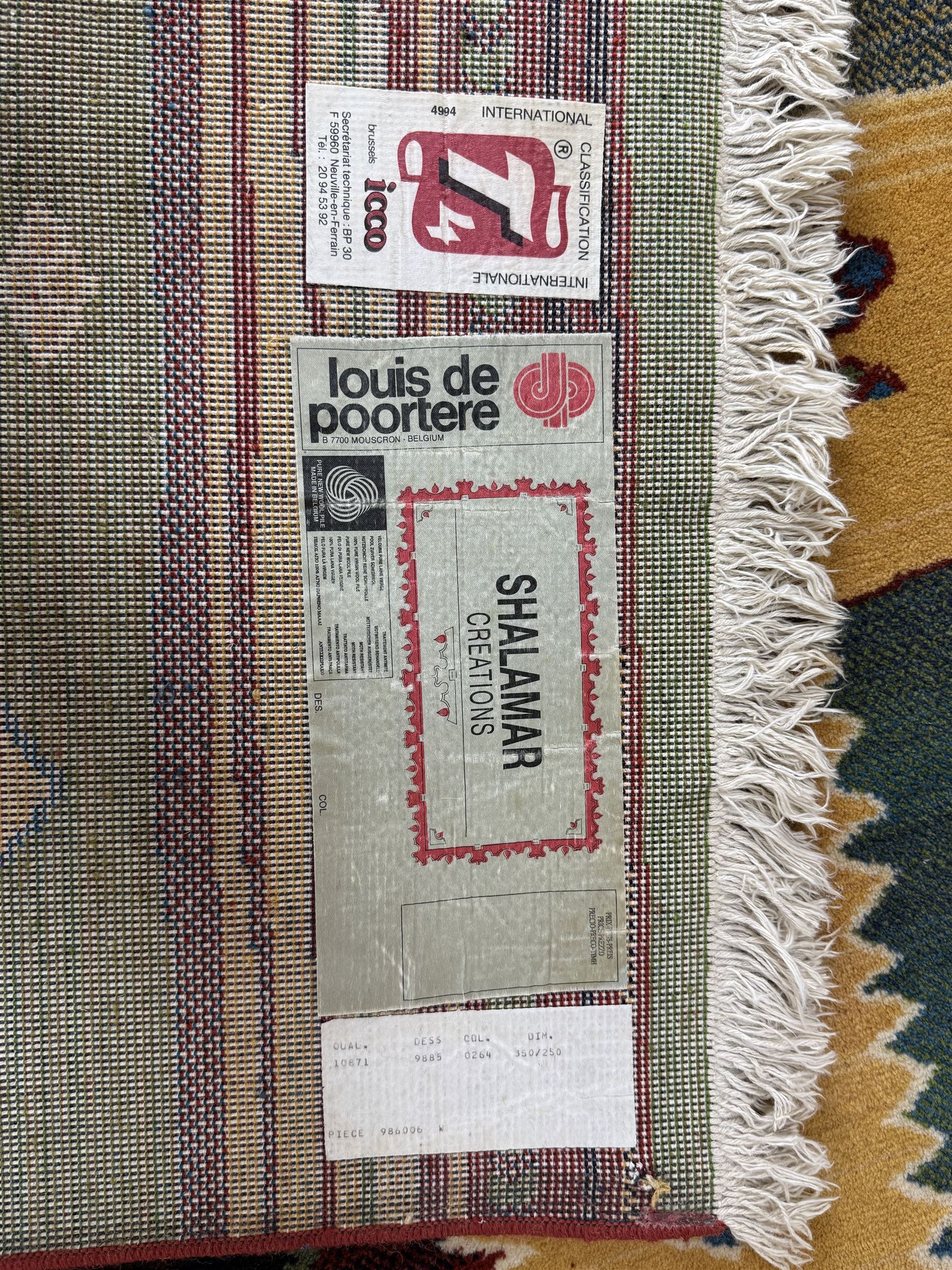 Late 20th century Louis De Poortere Belgian Shalamar wool ground rug, featuring a vibrant multi-coloured geometric design with stacked rectangular borders surrounding two central medallions, finished with fringed ends