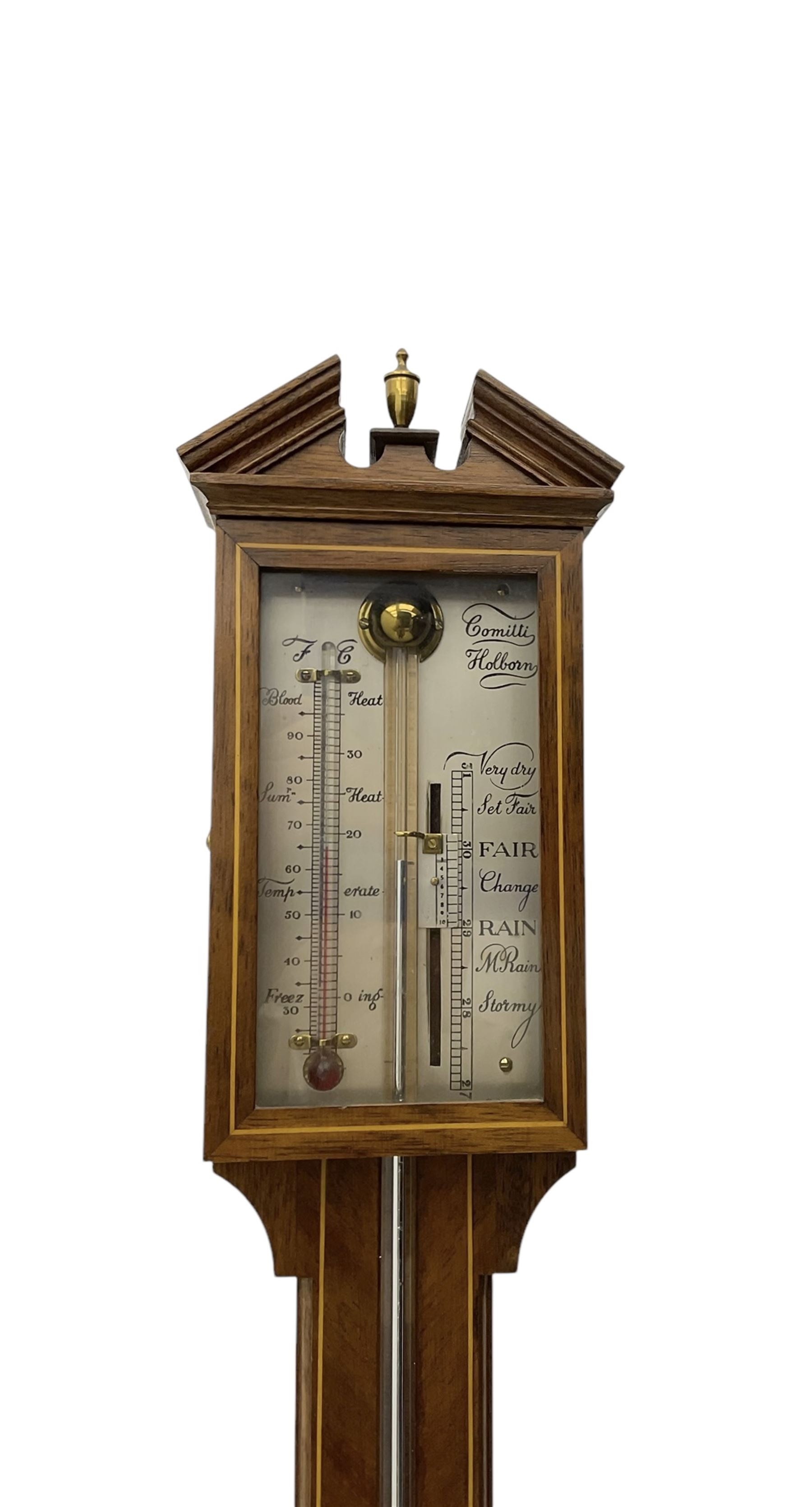 Comitti-20th century mercury stick barometer in an 18th century style mahogany case with satinwood stringing, with a broken pediment, brass finial and round base, silvered register with recording vernier, weather predictions and a centigrade/Fahrenheit spirit thermometer enclosed within a glazed door, visible tube with a bulb cistern and turned mahogany cover.
Mercury clean and present with no air locks.