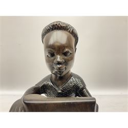 African hardwood figure carved from the solid as a man seated at a treadle sewing machine H33cm