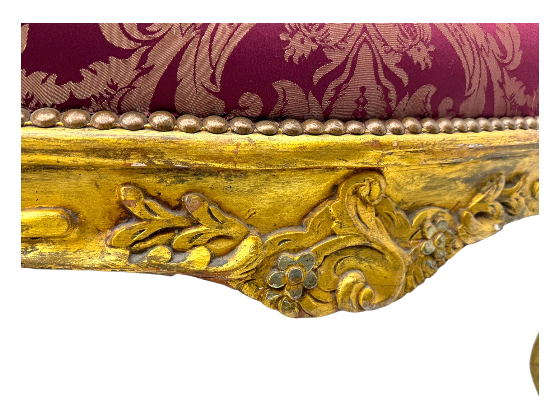 Pair of Louis XV-design giltwood stools, each upholstered in red damask fabric with slight variations in patterns, the carved frames adorned with scrolling foliage and shell motifs, raised on cabriole supports