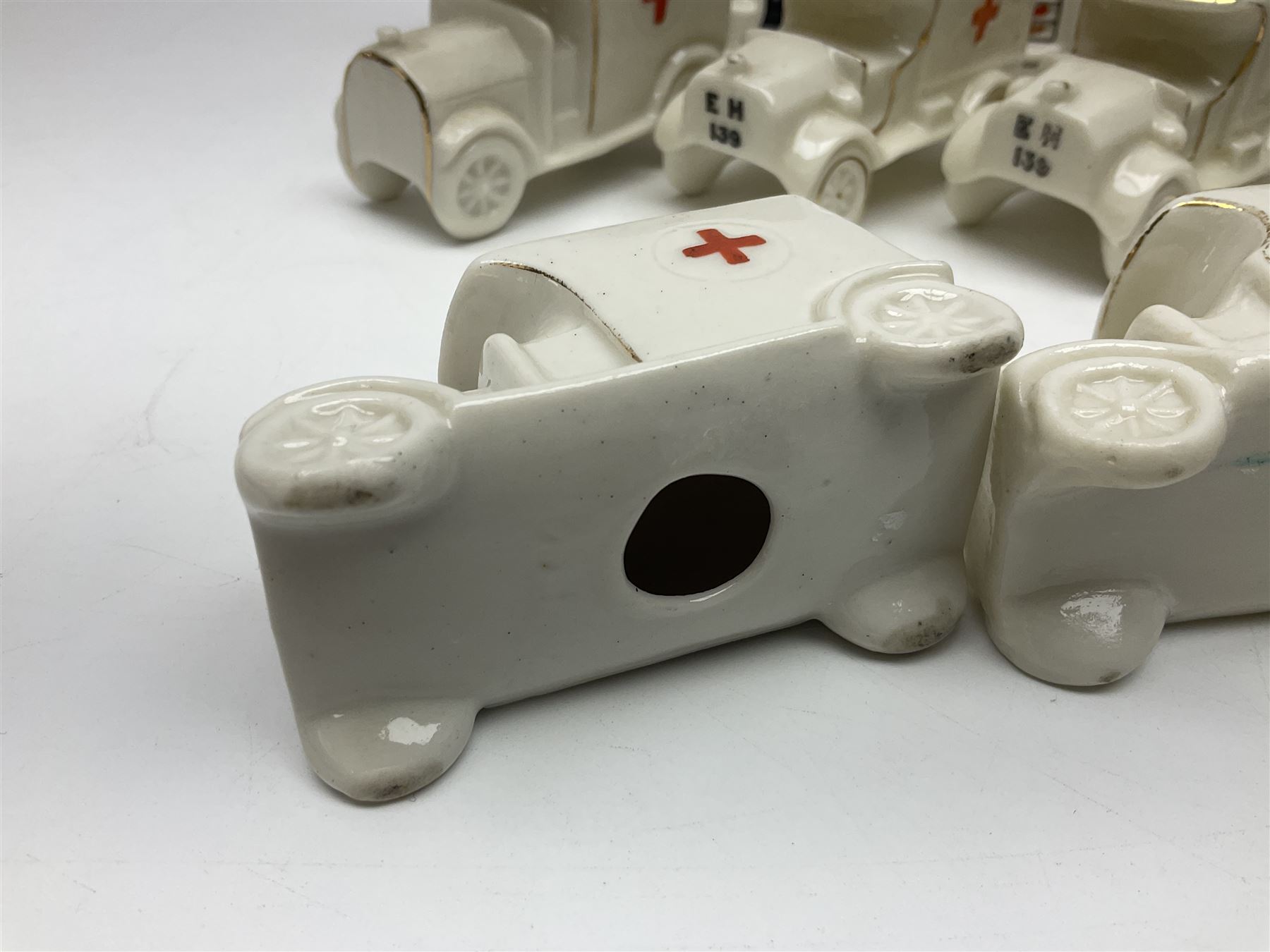 Ten WW1 crested china military models comprising seven field ambulances and three 'Home Fires Burning' fire-surrounds/range; various makers including Willow Art, Arcadian China, Grafton China, Savoy China, Carlton China etc; various crests including Devon, Aldershot, Portsmouth, West Ham, Coventry, Oxford, Hastings, Brighton etc (10)