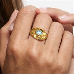 18ct gold Swiss blue topaz ring, bezel single oval cut topaz, within an abstract creased design setting, stamped 750