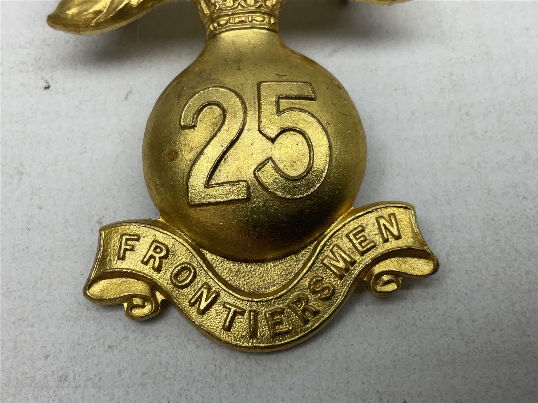 WW1 25th Battalion (Frontiersmen) City of London Royal Fusiliers Cap Badge; gilt brass fused grenade with 25 to the centre; circular section to the flames with red enamel cross and enamel union flag with GOD GUARD THEE to the centre; lower scroll with FRONTIERSMEN; two lug fittings verso.