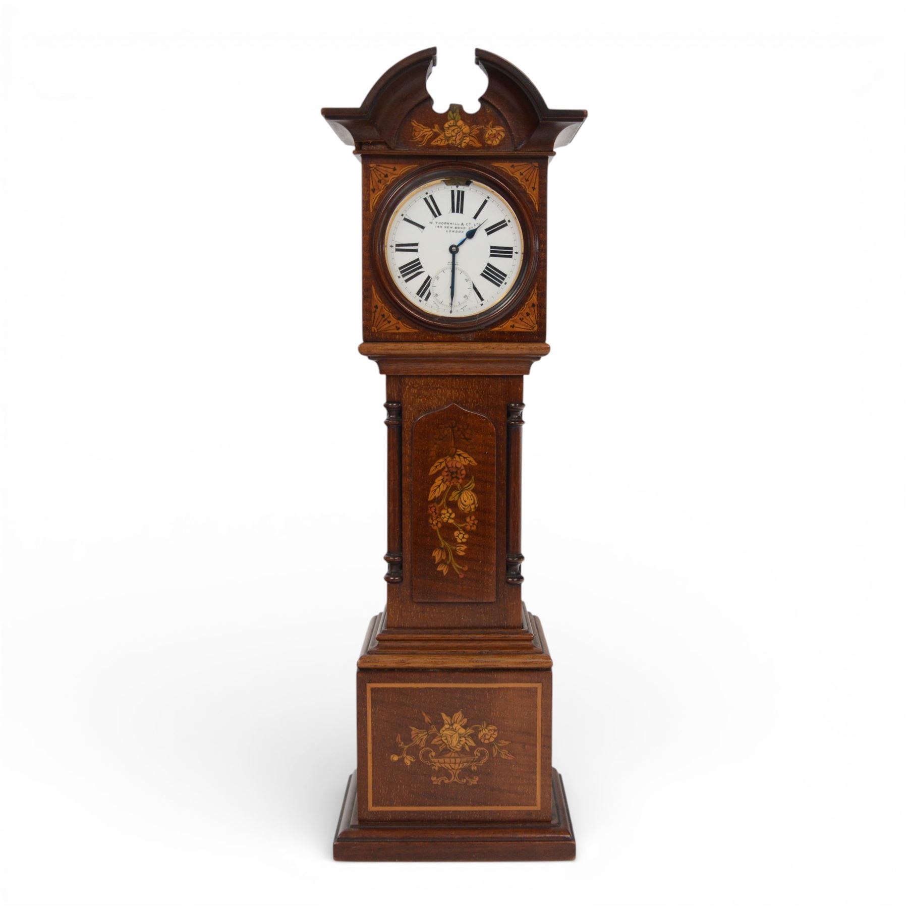 Edwardian mahogany and marquetry miniature longcase clock, the case with ogee top, over arched door flanked by turned columns, the base, door and top with classical urn and floral marquetry detail, housing goliath pocket watch, the white enamel dial with Roman numerals, chapter ring and subsidiary dial, and marked W. Thornhill & Co Ltd 144 New Bond St London, H38cm