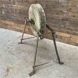 Vintage grindstone sharpening wheel mounted on metal stand, and a cast iron water pump