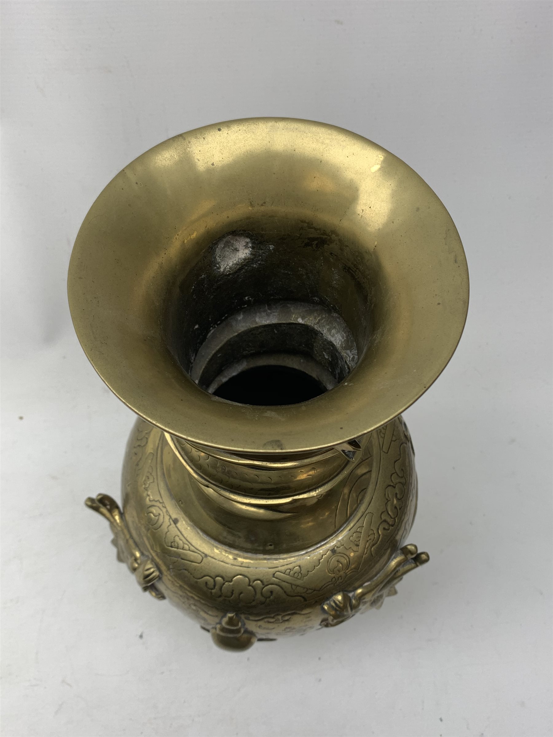 A large Chinese brass vase, of ovoid form with tall neck and flared rim, decorated in relief with dragons chasing a flaming pearl, and further incised with clouds and other detail, the base with relief dragon detail and character mark, H41