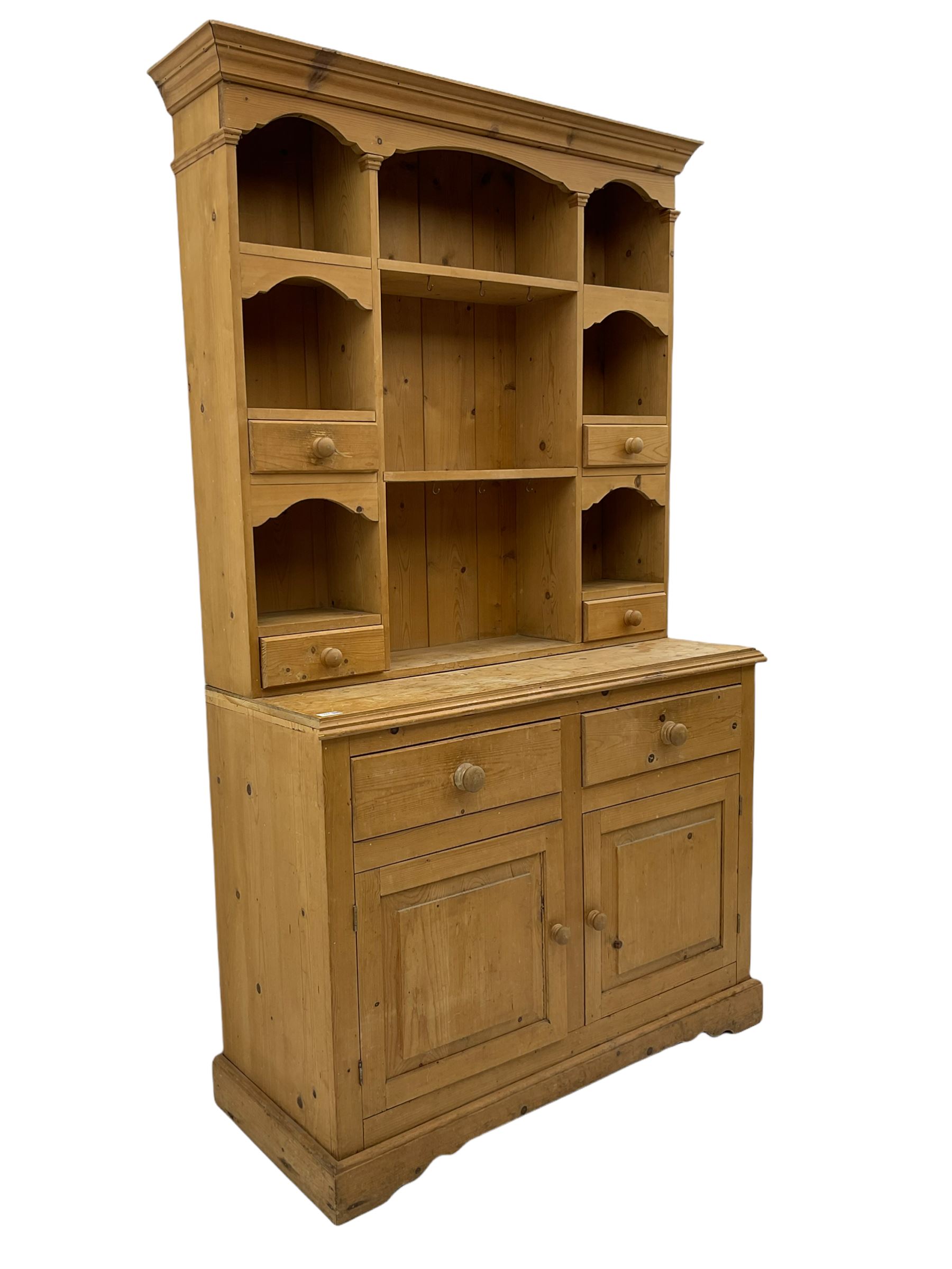 Solid pine dresser, raised plate rack fitted with small drawers over two drawers and double cupboard, plinth base