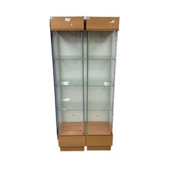 Pair light oak and glass open single display cabinets, glazed back and sides with three shelves, light fitting to top