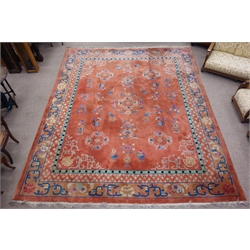  Early 20th century Chinese washed woollen carpet, peach ground decorated with floral motifs, 436cm x 362cm  