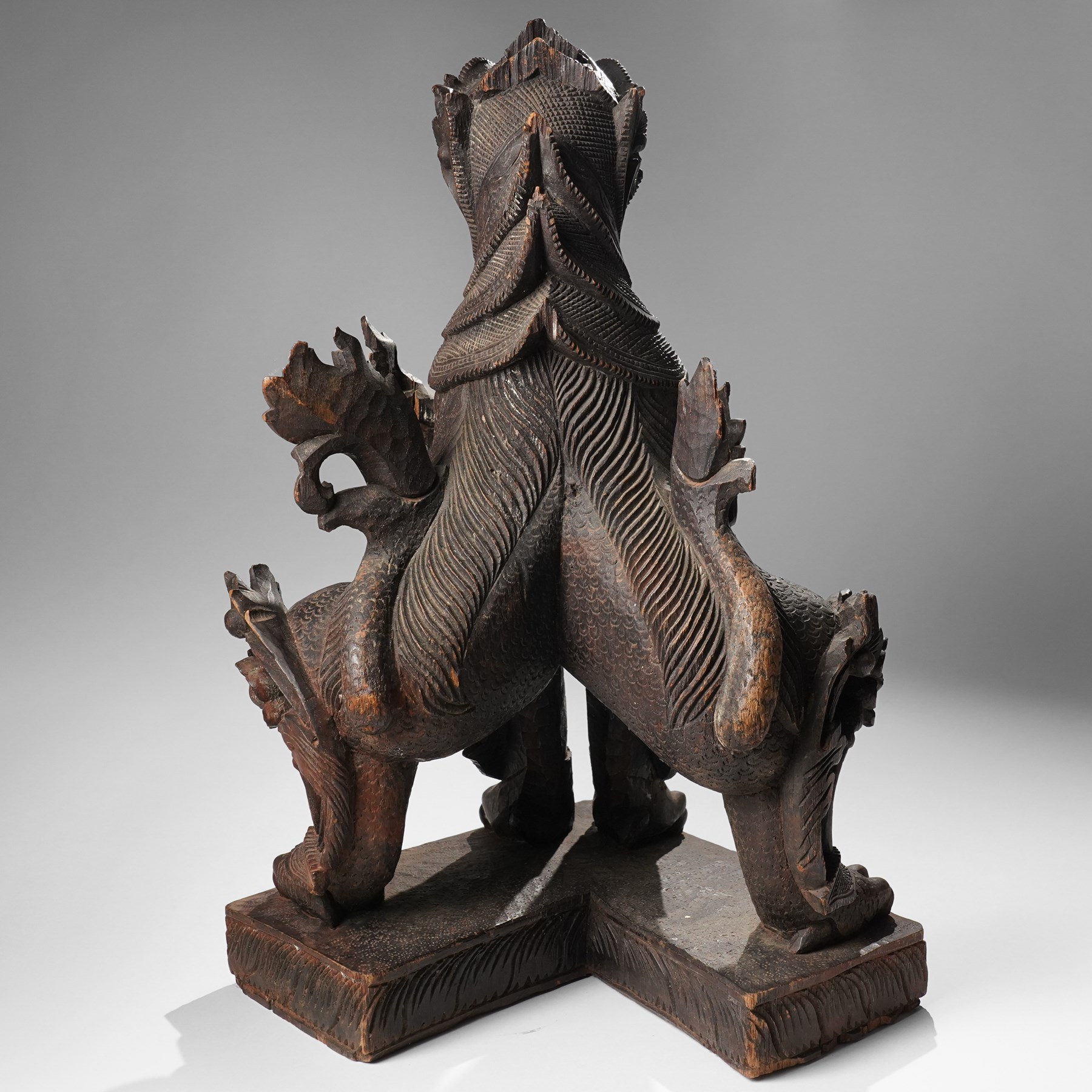 Burmese carved temple guardian figure, depicted seated with carved flame details, H52cm 
