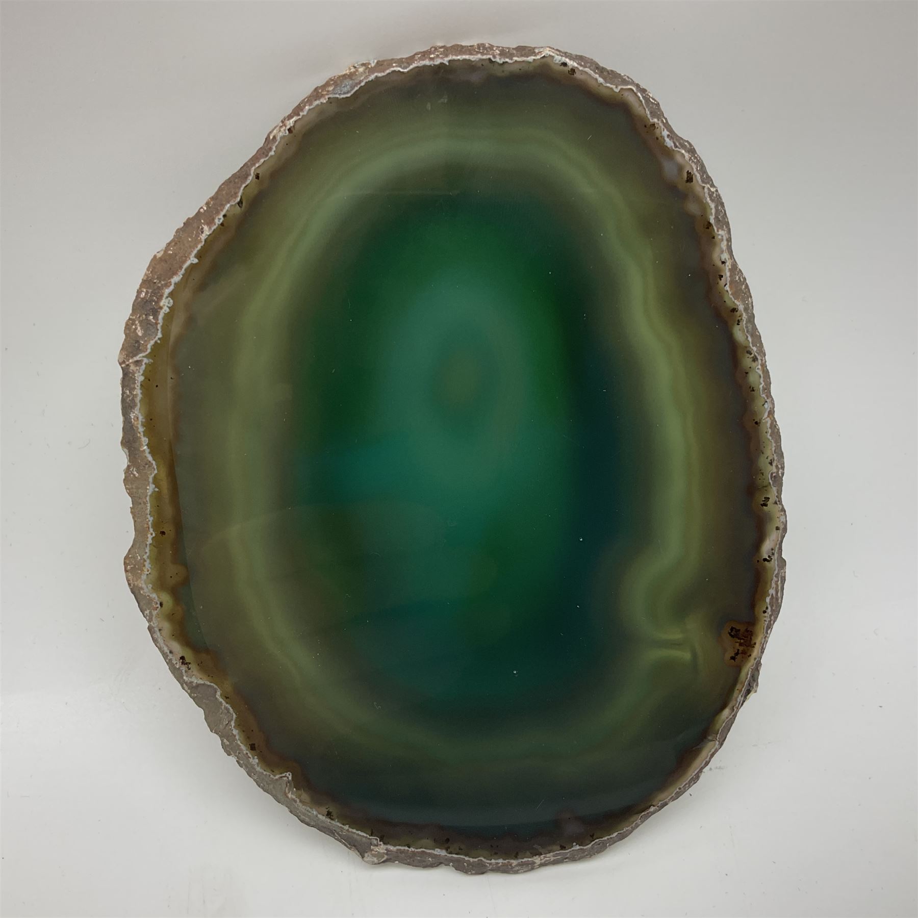Pair of green agate slices, polished with rough edges raised upon silvered metal stands, H19cm