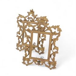 Rococo style cast gilt metal table mirror, the oval mirror plate within an open C scroll and foliate detailed frame, with easel style support verso, H33cm, together with a pair of cast gilt metal acanthus surround frames, H28.5cm