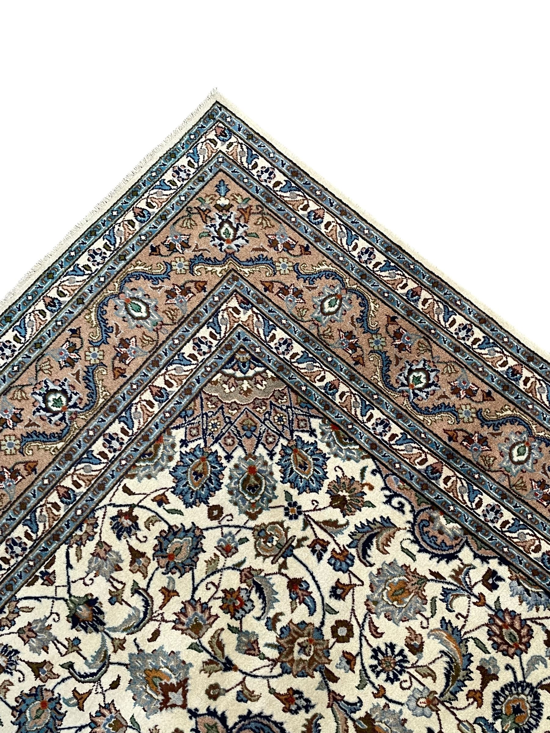 Persian Kashan ivory ground rug, the central medallion surrounded by an arrangement of palmettes united by scrolling leafy branches, peach ground main border decorated with trailing leaf and stylised plant motifs, floral pattern guard stripes 