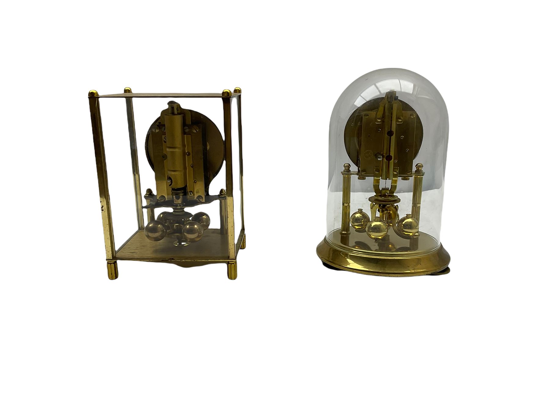 A 20th century English Torsion clock marketed by Bentime Ltd, London, with a four-ball rotary pendulum, white dial with gilt Arabic numerals and pierced gilt hands, under a glass dome, base with adjustable feet. No key.
Bentime Ltd did not make clocks but marketed clocks made by other companies such as J D Francis and Perivale.
H17
With a German Kundo torsion clock in a glazed rectangular case with four glass sides, four-ball rotary pendulum, white painted dial with gilt three-hour Arabic numerals and batons, with pierced brass hands. No key.
H15 W11 D9
