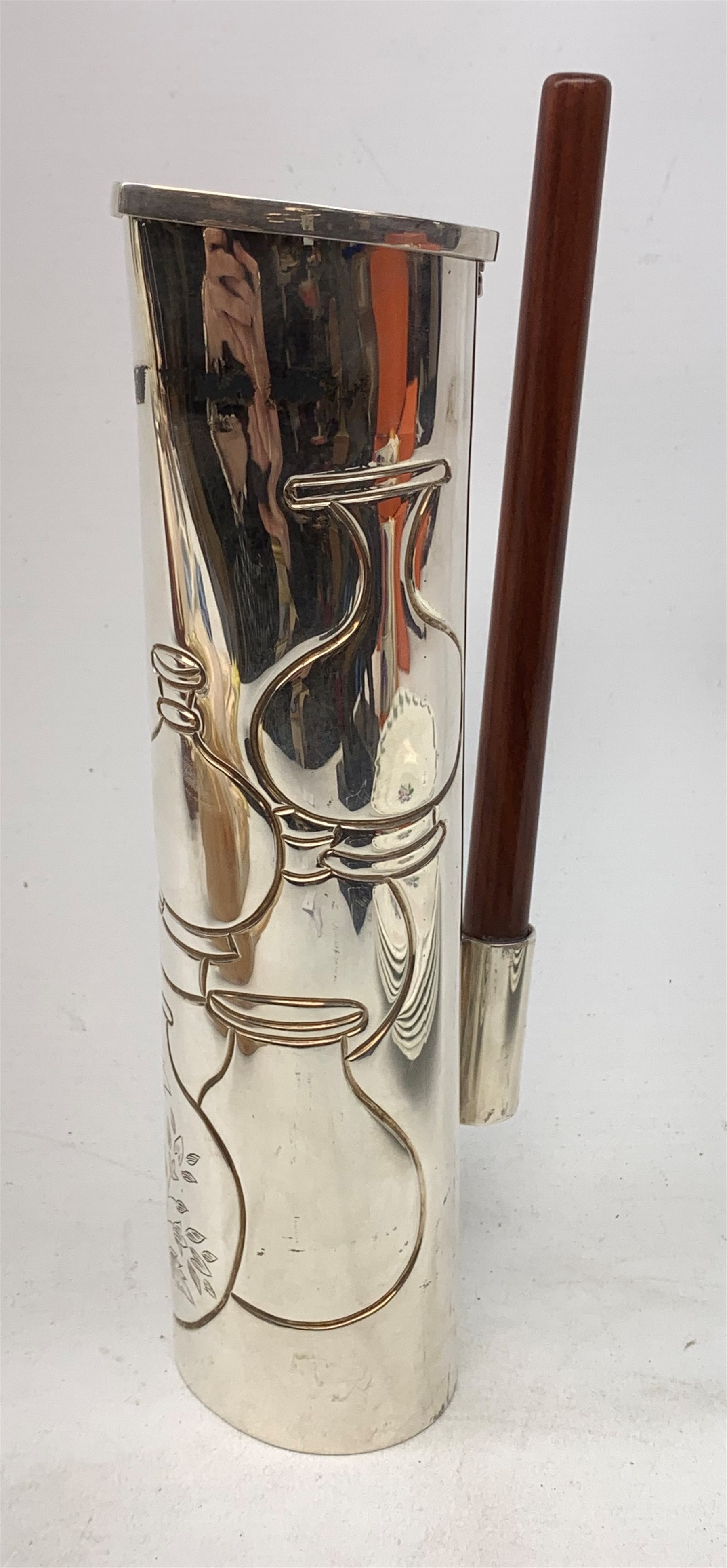 A silver plated Ravissant water jug, of cylindrical form with wooden open handle, detailed with a group of vases, marked beneath Ravissant, H25.5cm.  