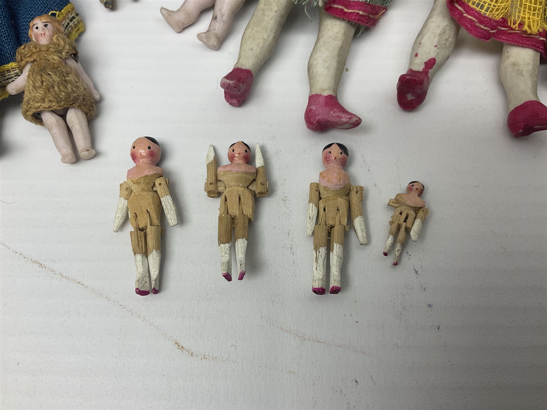 Twelve miniature bisque, bisque headed and wooden dolls to include articulated examples, tallest 12cm 
