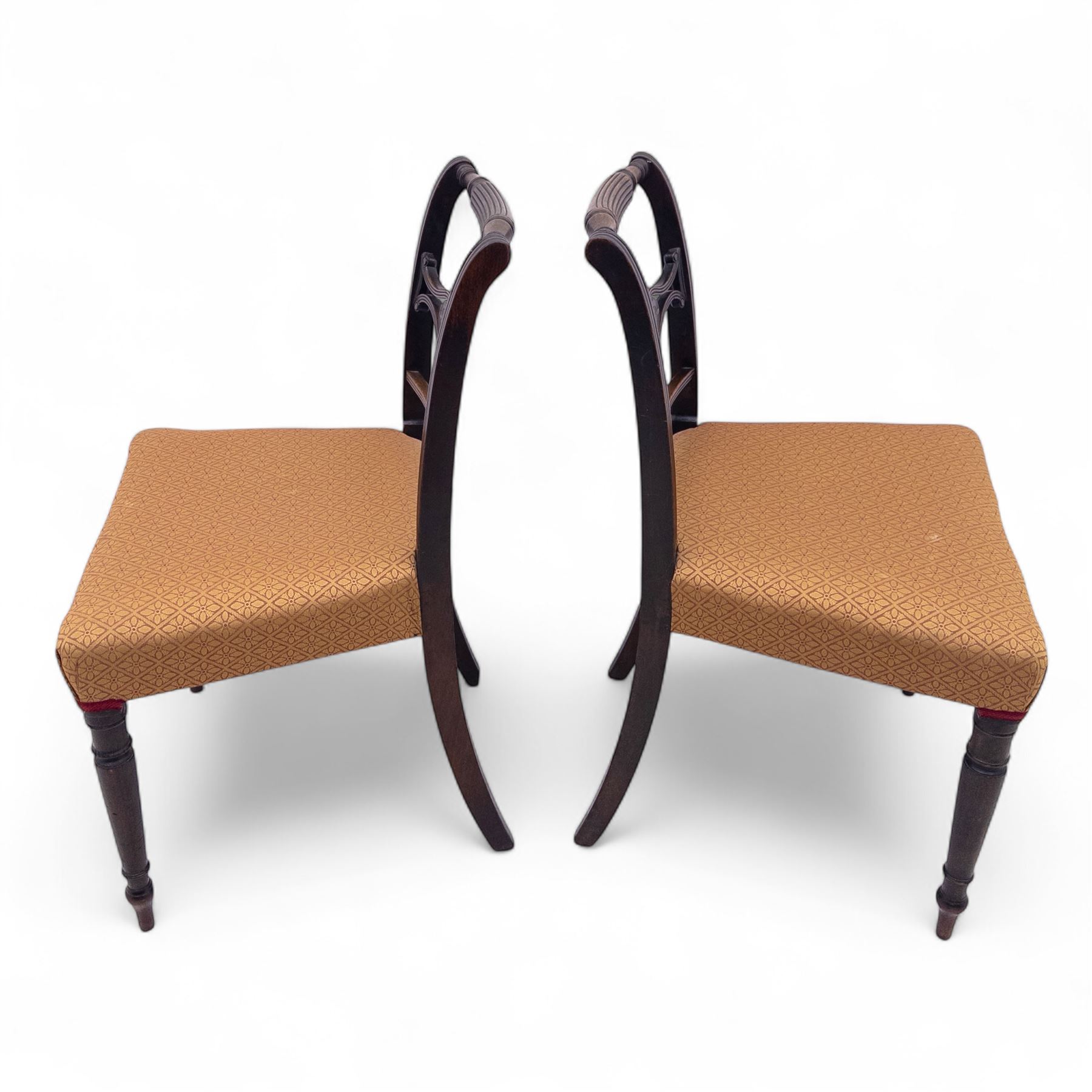 Pair of Regency mahogany side chairs, reeded bar backs centred by oval paterae, overstuffed seats upholstered in gold geometric patterned fabric, on turned tapering front supports 