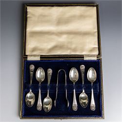 Set of six 1920s silver teaspoons and pair of sugar tongs, each decorated in relief with t...