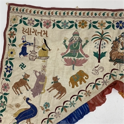 Early 20th century Indian Toran, embroidered in bright colours with figures and animals and Ganesh seated to the centre, within a floral trailing border and ruffle trim, W112cm x 115cm 
