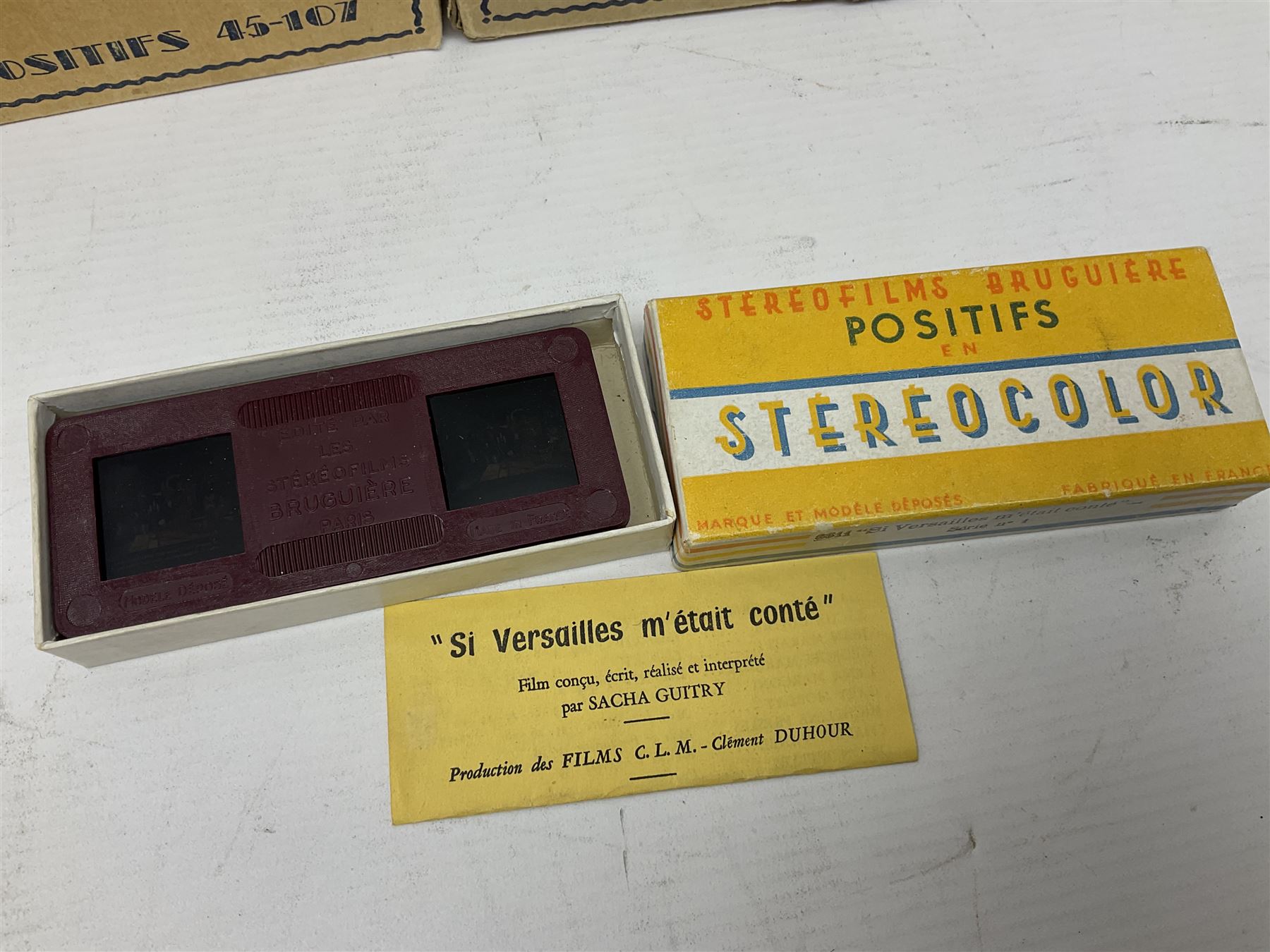 Two Stereofilms Bruguiere stereoscopes with seven boxes of related stereo positive slides to include one colour example entitled ‘Si Versailles m’etait conte’ Serie No.1, all in original boxes