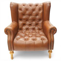 Alexander James design fully tan leather chair, with full button back seat and back, with scrolled arms with studded trim, raised on light stained turned supports