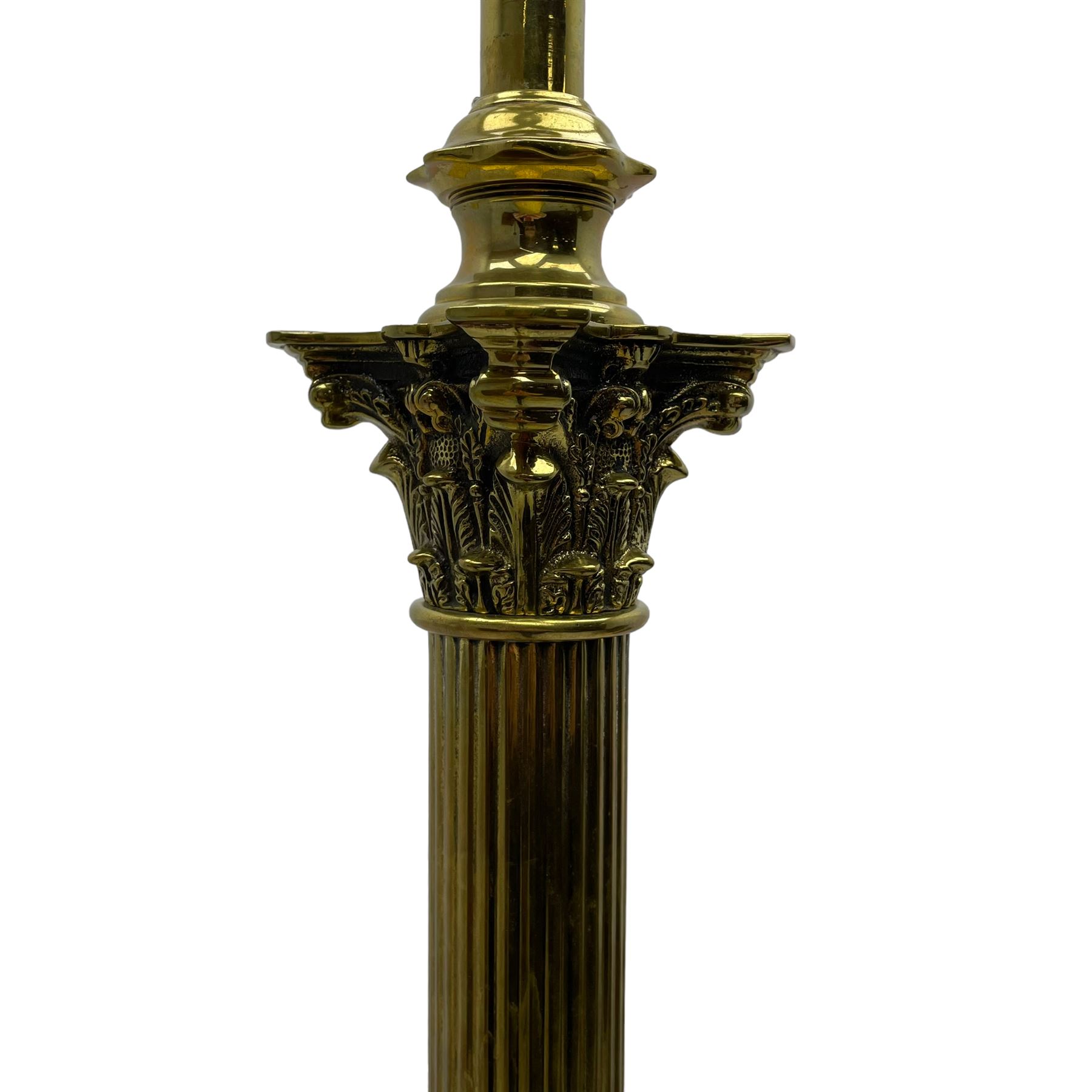 Late 20th century brass telescopic standard lamp in the form of a Corinthian column, Corinthian acanthus leaf capital over reeded shaft, stepped and moulded square base with four extending ball and claw feet