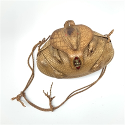 A lady's shoulder bag of rugby ball shape formed from a lined armadillo skin with head and limbs, enamelled clasp, inset glass eyes and plaited strap, W25cm.
