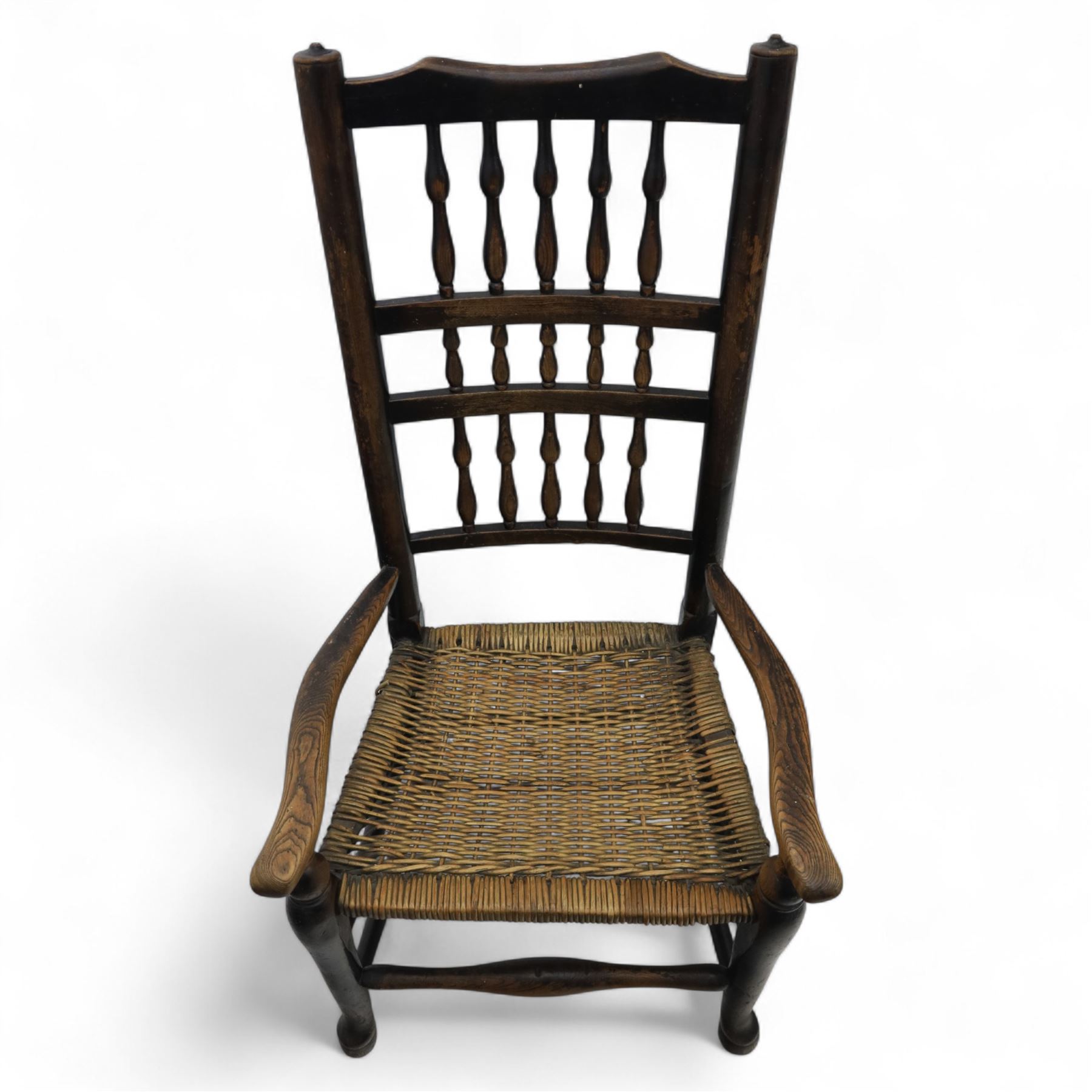 19th century country elm spindle back armchair, shaped cresting rail over two rows of turned spindles, shaped open arms over rush seat, on front turned supports, joined by stretchers 