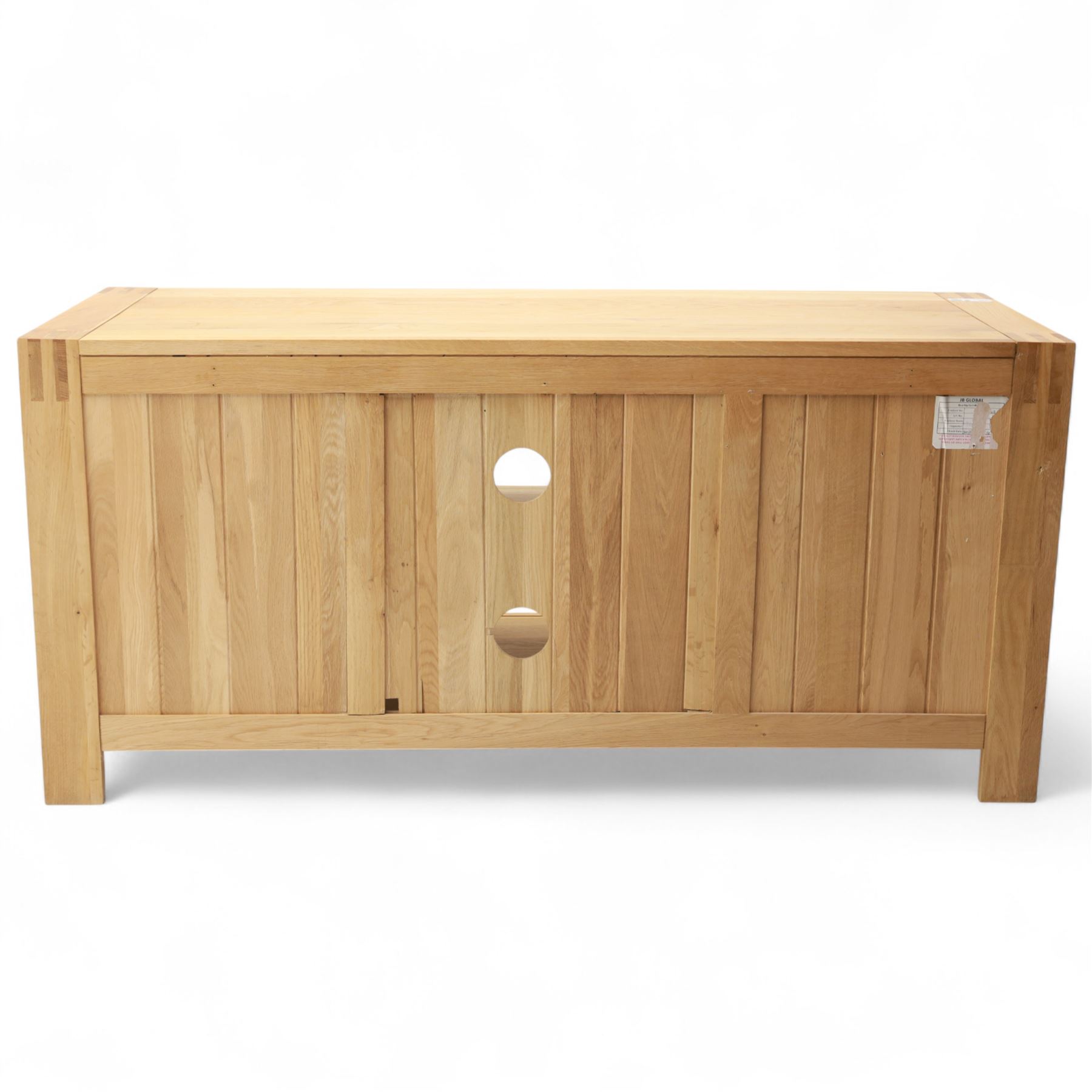 Contemporary solid oak television stand, rectangular top over an open central section with adjustable shelf, flanked by cupboard doors with vertical recessed panel fronts and brushed steel handles, on block feet