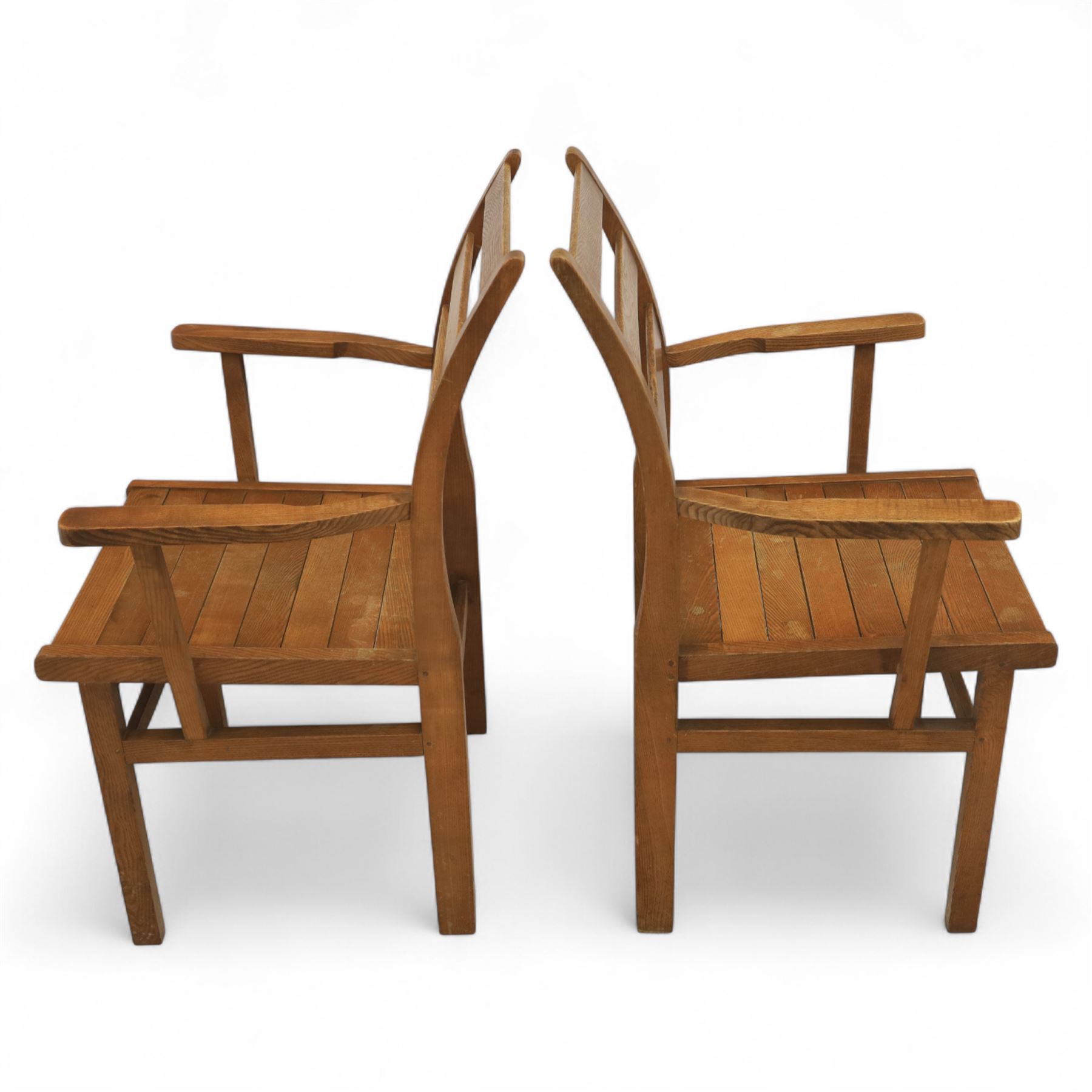 Treske of Thirsk - solid oak refectory dining suite, rectangular top with chamfered edge over trestle base united by a central stretcher, together with six matching slat back dining chairs, including two carvers, with panelled seats and square legs united by stretchers (H 87cm, W 62cm, D 57cm)