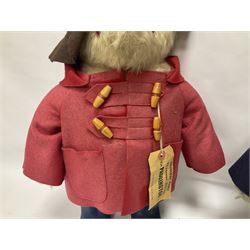 Pair of Paddington Bear teddies with amber eyes, the first example having a brown felt hat, red coat and blue PB boots with original label; the second having a grey felt hat, blue coat and blue Dunlop boots, tallest H51cm 