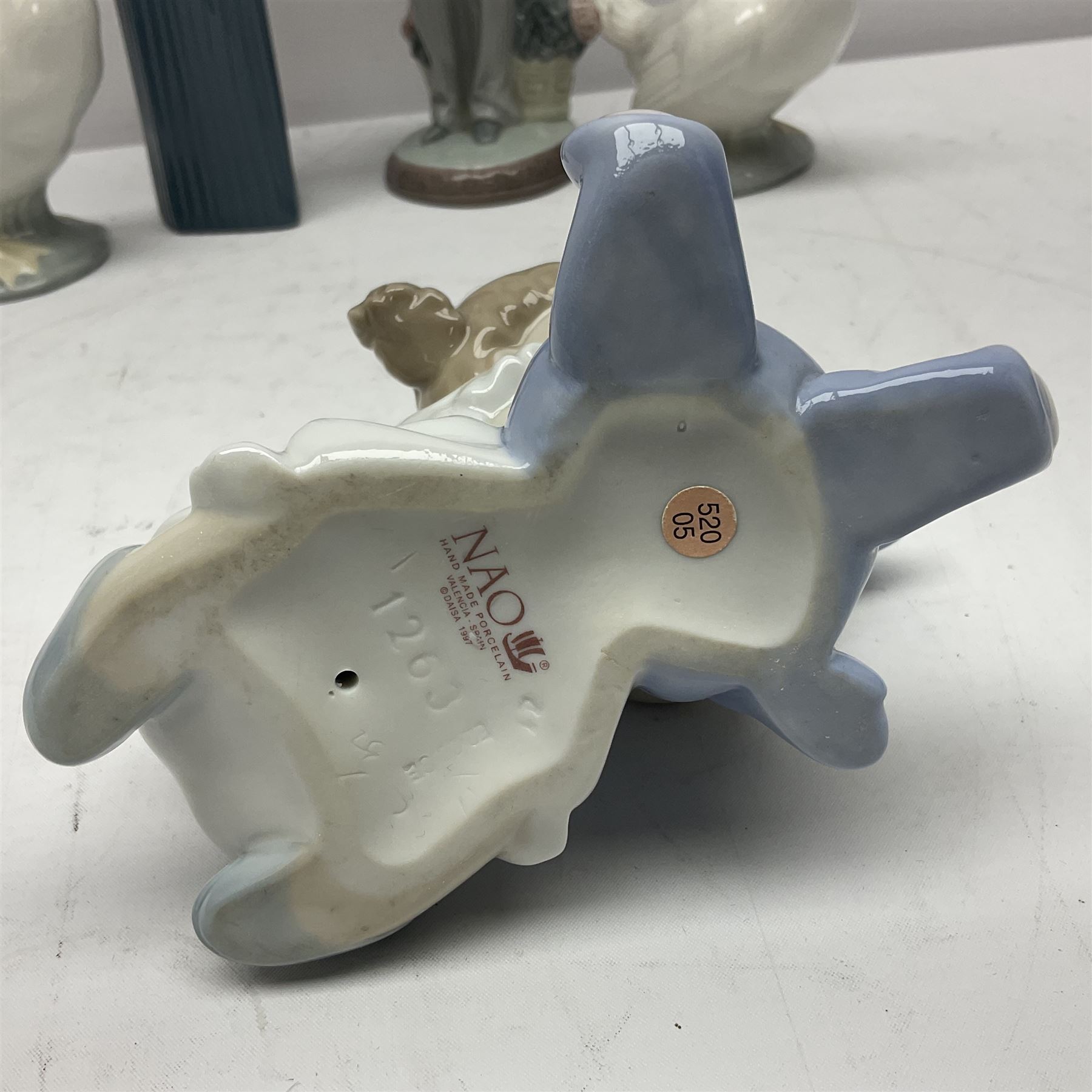 Two Lladro figures, Over the Threshold no 5282 and Prayful Moment no 5500 together with five Nao figures