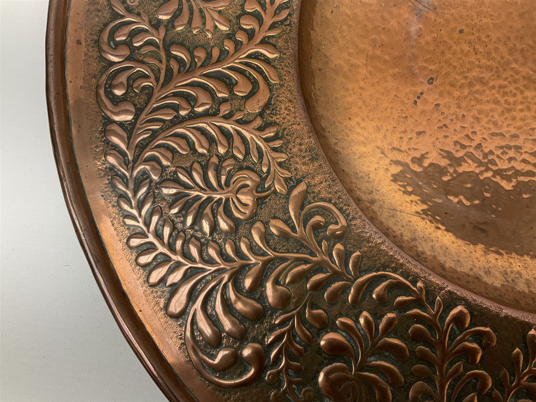 Arts and Crafts Keswick School of Industrial Arts copper charger, decorated with planished centre and repousse scrolling foliate tendrils to rim, D44cm