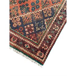 Persian Joshaghan rust ground rug, stepped lozenge medallion surrounded by repeating foliate lozenge motifs, the border decorated with stylised plant motifs, within geometric guard stripes
