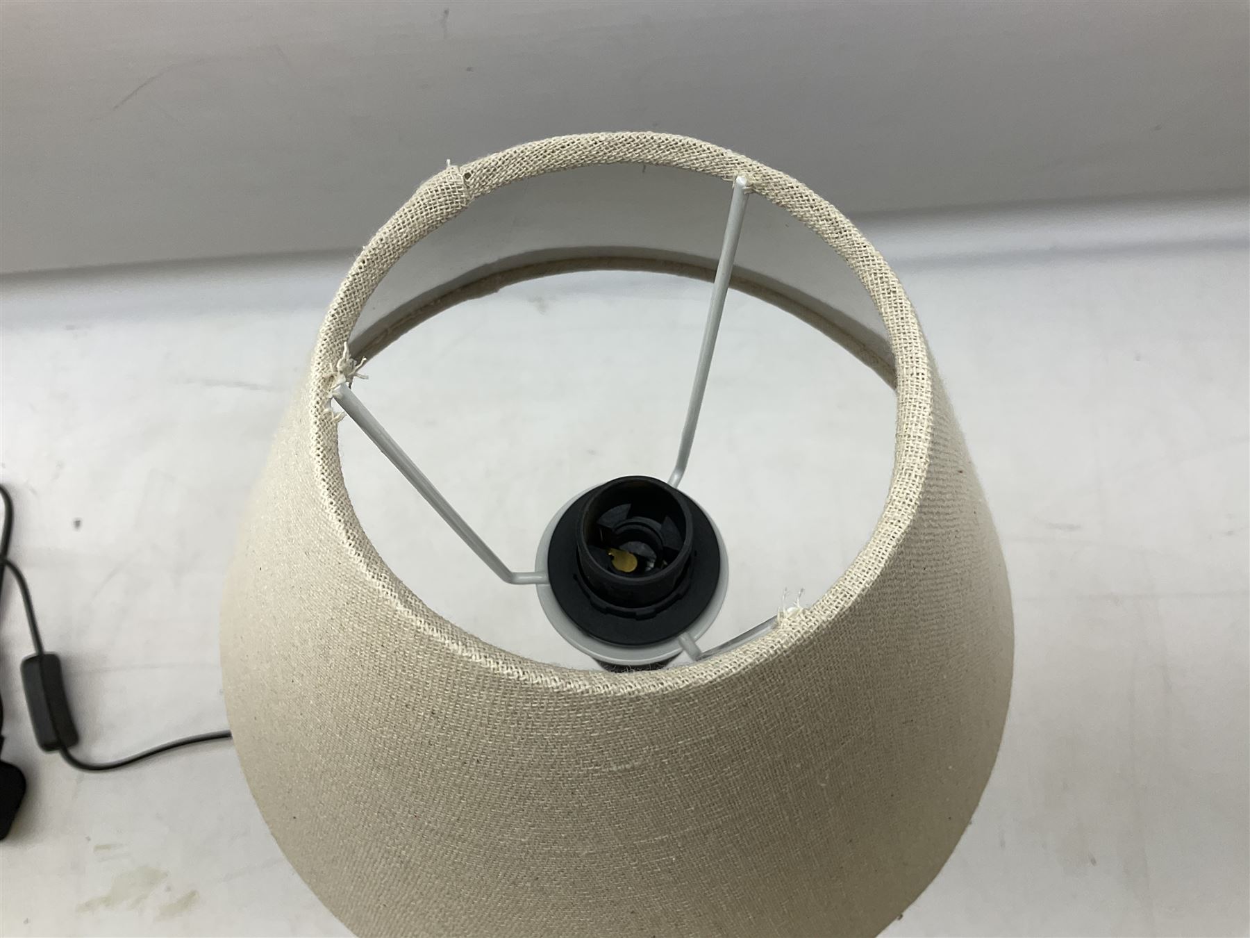 Table lamp, with a thin central stem upon a square stepped base, natural linen shade