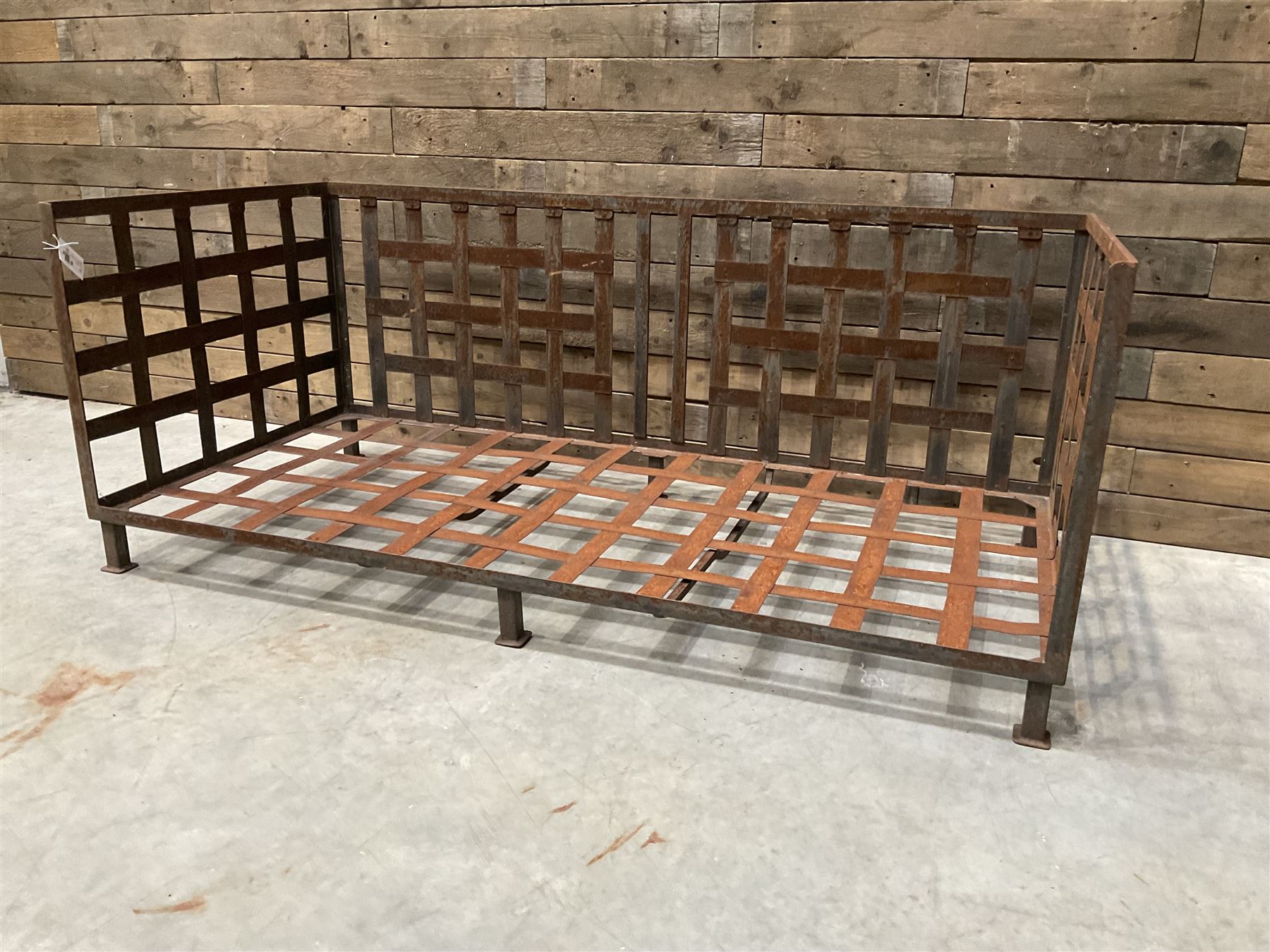 Wrought iron strapwork garden day bed, lattice back and sides