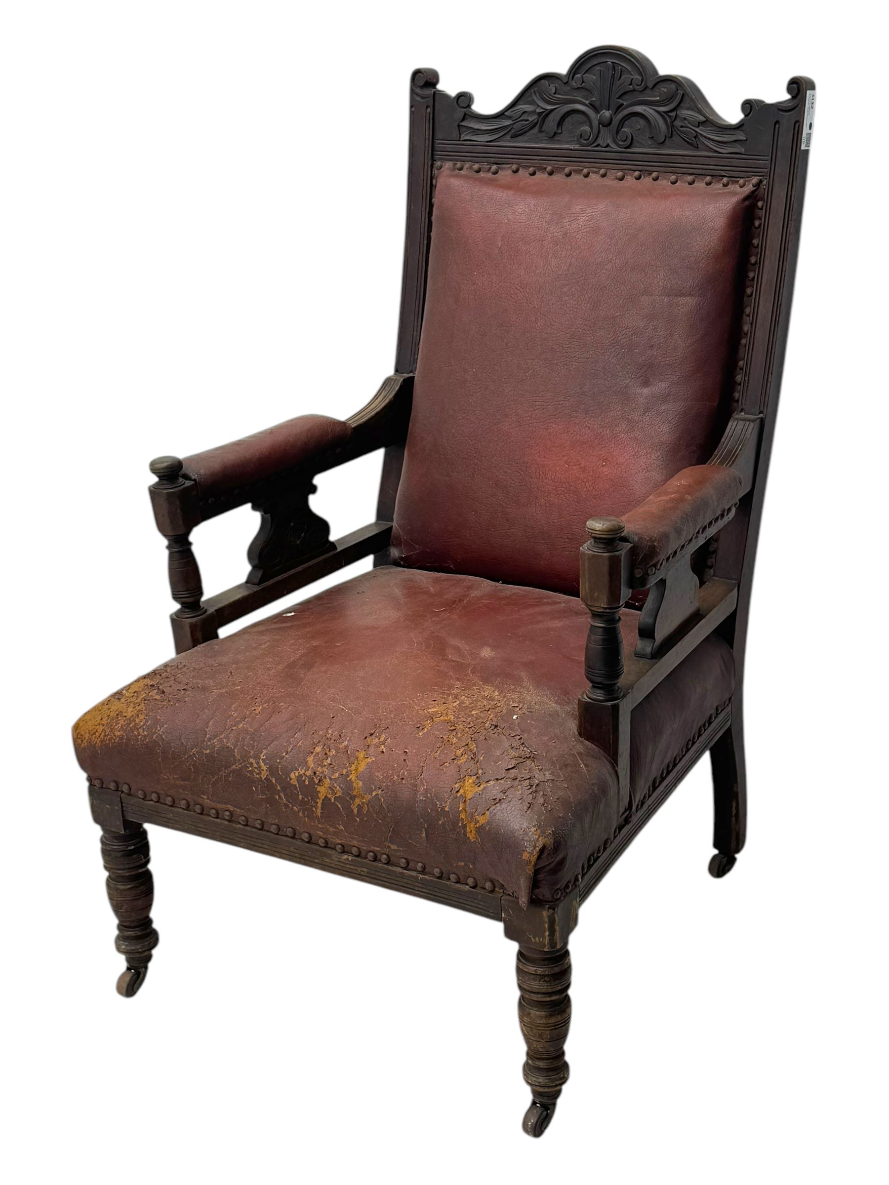 Victorian walnut framed armchair, shaped pediment carved with scrolling foliage, upholstered in leather, on ring turned front feet