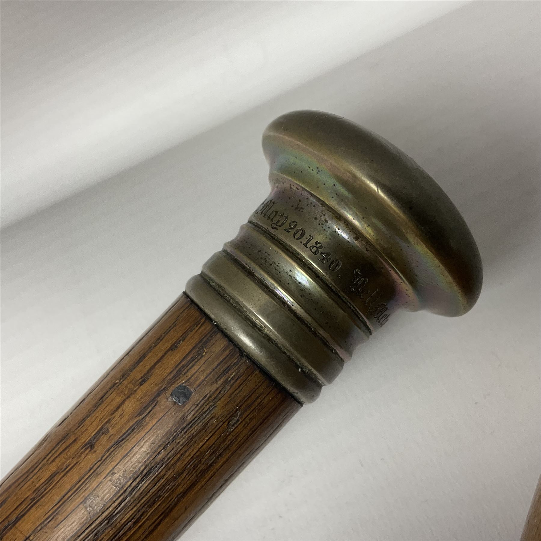 Three early 20th century walking sticks, to include a smoking pipe walking stick, the cane opening to reveal a concealed pipe, and a wooden walking cane, the metal cover with inscription 'bell metal and wood of York Minster, Burnt May 20 1840, and a turned wooden walking stick, with marquetry checkerboard pommel, tallest L90cm