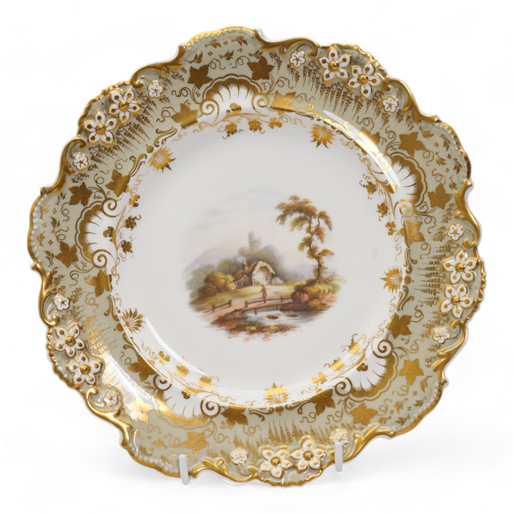 Davenport porcelain dessert plate, painted with a figure and cottage in a rural landscape, within a raised gilt border, D24cm, a 19th century English porcelain twin handled dessert dish, together with an early 19th century porcelain cabinet plate, painted with a river landscape within a gilt border, possibly Derby, unmarked, D22cm (3)