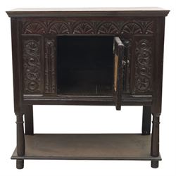 19th century oak cupboard cabinet, the moulded rectangular top above a deeply carved front carved with frieze of lunettes above a central panelled cupboard door with lozenge and foliate carving, flanked by vertical carved panels, upon turned legs with boarded lower shelf