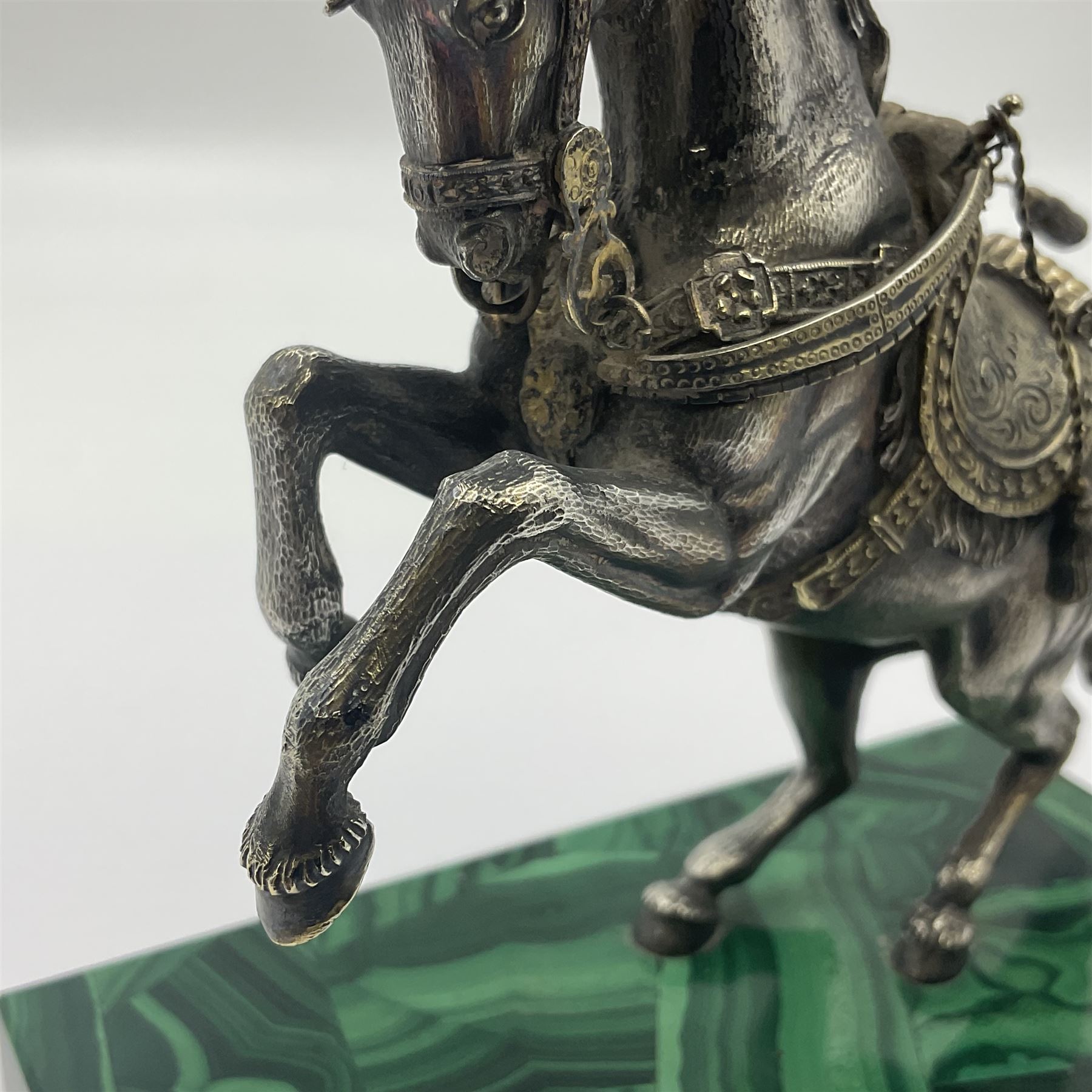 Modern silver model of a rearing horse, with ornate parcel gilt saddle and bridle, mounted upon a rectangular base, decorated with malachite panels to each side and upon four gilt bun feet, horse stamped 925, overall H14.5cm