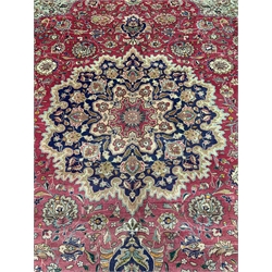 Persian Kashan rug carpet, pale red ground field with overall stylised foliate design, decorated with floral central medallion and spandrels, the blue ground border with six band guard, 370cm x 295cm