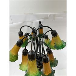 Art Nouveau Tiffany style table lamp, the bronzed base modelled as lily pads leading to tendrils and twelve branches supporting green and yellow glass lily flower shades, H53cm