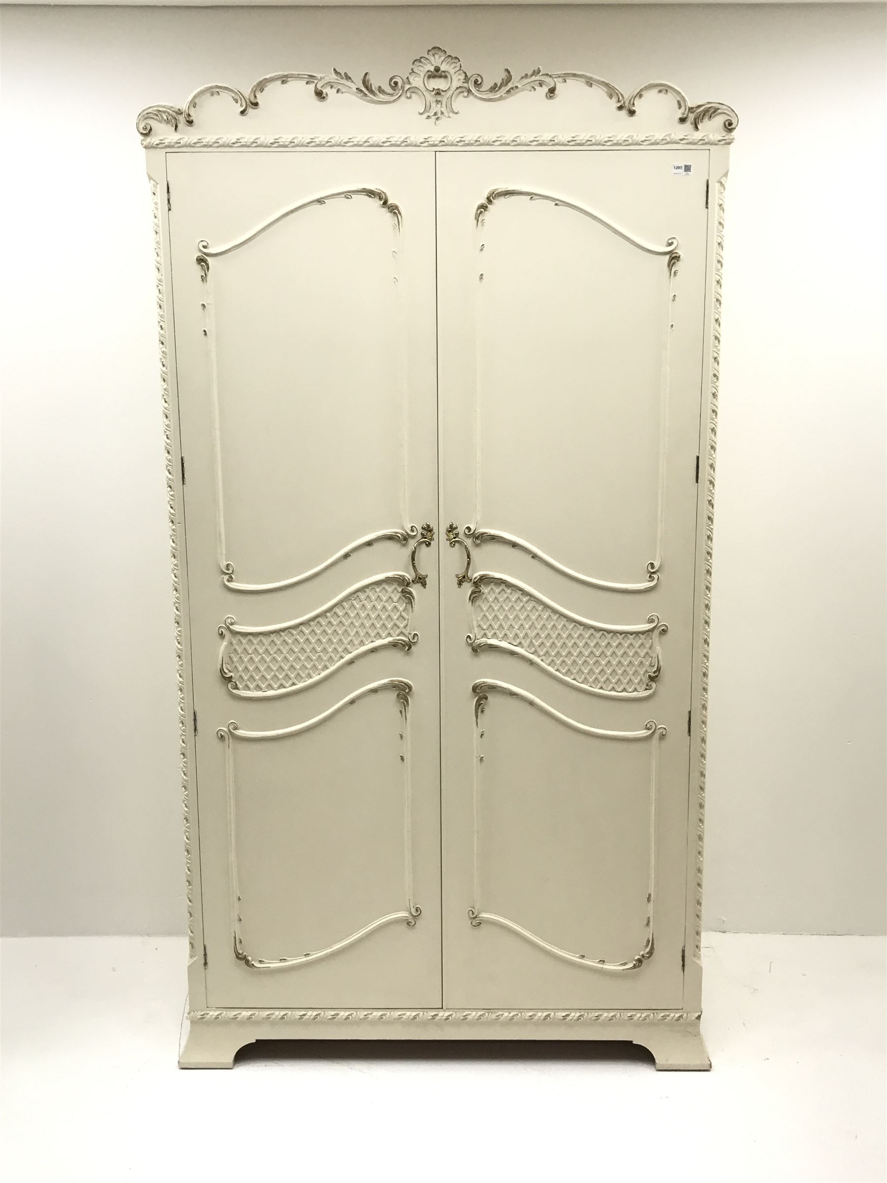 Late 20th century French style white and gilt double wardrobe,  shell carved cresting rail, two doors enclosing fitted interior, shaped bracket supports