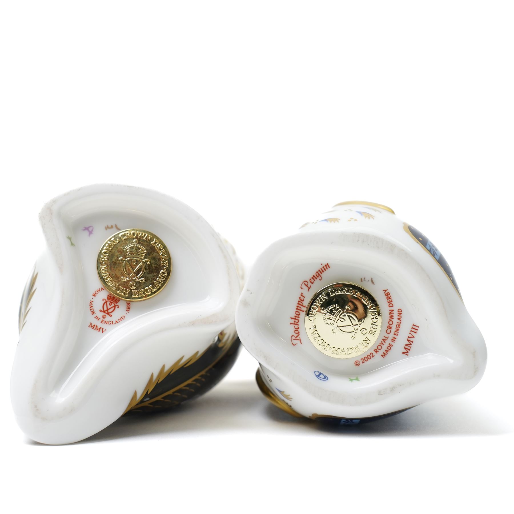 Three Royal Crown Derby paperweights, comprising Puffin with gold stopper, Rockhopper penguin with gold stopper, and Penguin and Chick with gold stopper, two with boxes (3)