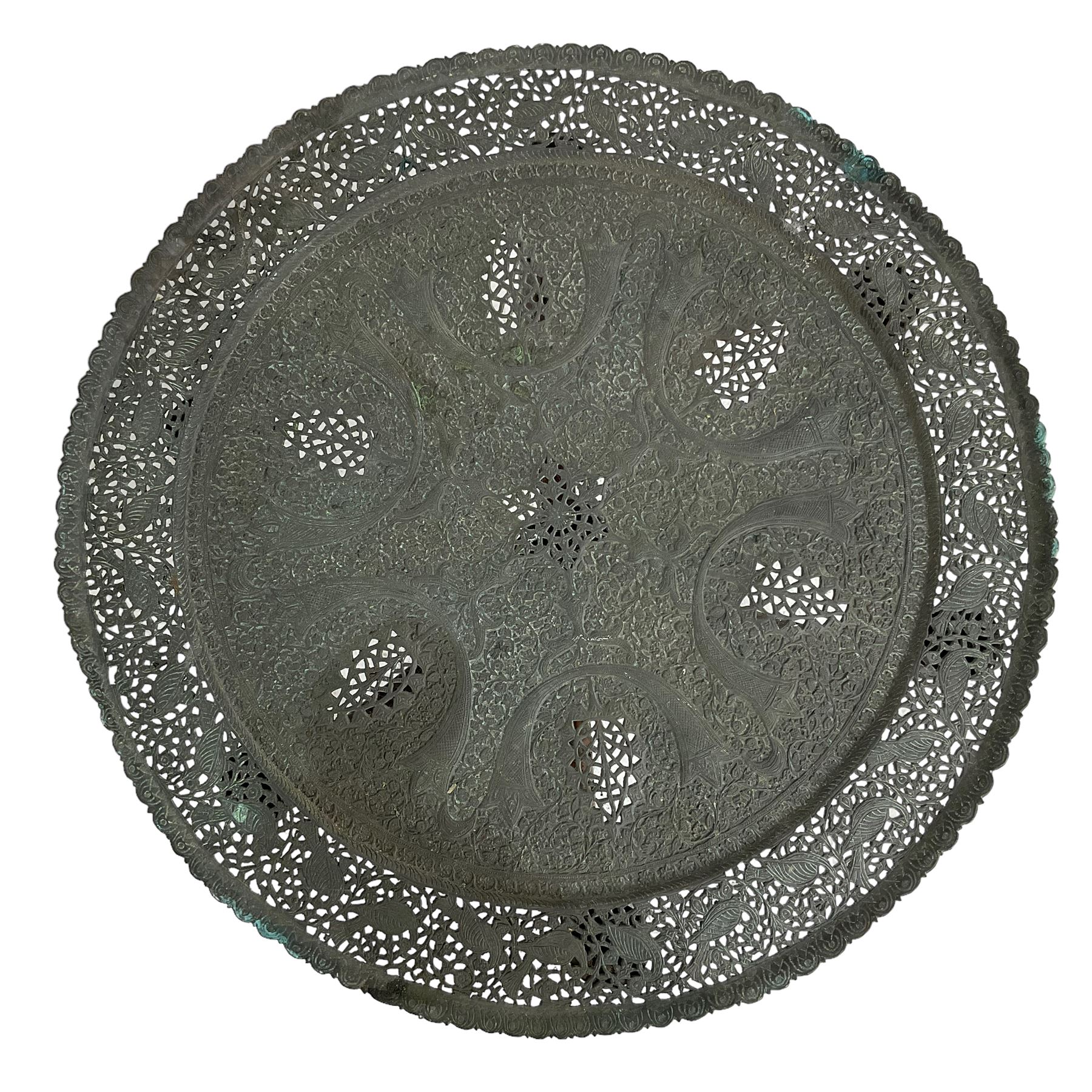 Anglo-Indian Benares table, circular pierced copper top decorated with trailing foliage, on folding hardwood stand carved with scrolls and incised decoration