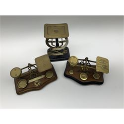 Pair of German Jacob Maul bilateral brass and black enamel postal scales H16cm; and two sets of brass postal scales, each displaying postal rates on serpentine hardwood bases inset with various brass weights (3)